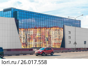 Отражение новостроек в стеклянном фасаде строящегося многофункционального торгового центра «Мой Молл» на Новорязанском шоссе. Деревня Островцы, Раменский район, Московская область (2017 год). Редакционное фото, фотограф Владимир Сергеев / Фотобанк Лори