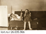 Отец читает газету, дочь сидит рядом на диване. 1970 год. (2017 год). Редакционное фото, фотограф Светлана Попова / Фотобанк Лори