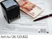 Оплата налогов. Чистый бланк налоговой декларация, российские деньги, шариковая ручка и печать предпринимателя (2017 год). Редакционное фото, фотограф Игорь Низов / Фотобанк Лори