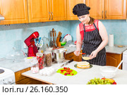 Молодая хозяйка пропитывает кулинарной кистью корж торта. Стоковое фото, фотограф Сергей Дубров / Фотобанк Лори