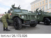 Солдат российской армии подкрашивает колесо бронеавтомобиля "Тигр". Подготовка к военному параду в честь Дня Победы. Санкт-Петербург (2017 год). Редакционное фото, фотограф Виктор Карасев / Фотобанк Лори