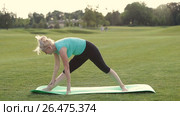 Healthy adult woman doing yoga exercises outdoors. Стоковое видео, видеограф Швец Анастасия / Фотобанк Лори