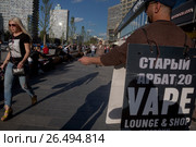 Мужчина рекламирует Vape shop (магазин электронных сигарет) на Новом Арбате в городе Москве, Россия (2017 год). Редакционное фото, фотограф Николай Винокуров / Фотобанк Лори