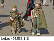 МОСКВА, 9 МАЯ 2010: Два мальчика-малыша в военной форме Советской армии времен Великой Отечественной войны с автоматом ППШ ППД и винтовкой Мосина со штыком на праздновании 65-ой годовщины Великой Победы 9 мая. Парк Горького MOSCOW, MAY 9, 2010: Two young boys brothers in green USSR WWII uniform with soviet machine gun, rifle on celebration of Great victory 65th anniversary in Gorky Park garden. USSR 9 May Victory day. Редакционное фото, фотограф Mikhail Leonov / Фотобанк Лори