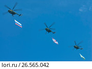 MOSCOW, MAY 9, 2010: Three green helicopters Mi-8 with Russian army flags above Red Square on celebration of Great victory 65th anniversary. USSR victory in Second World War. 9 May Victory day. Редакционное фото, фотограф Mikhail Leonov / Фотобанк Лори