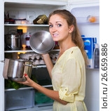 Hungry female standing near fridge with pan of food. Стоковое фото, фотограф Яков Филимонов / Фотобанк Лори