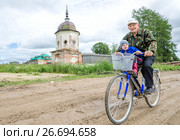 Александро-Ошевенский монастырь. Деревенский житель едет на велосипеде. Россия, Архангельская область, Каргопольский район (2010 год). Редакционное фото, фотограф Яковлев Сергей / Фотобанк Лори