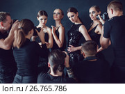 Photographers paparazzi take photos of women in cocktail dresses on dark background. Стоковое фото, фотограф Женя Канашкин / Фотобанк Лори