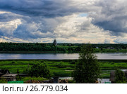 Небо перед дождем. Деревянный храм на берегу реки. Россия, Архангельская область, деревня Подпорожье (2017 год). Стоковое фото, фотограф Яковлев Сергей / Фотобанк Лори