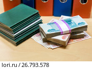 Трудовые книжки и пачки российских денег на фоне деловых папок. Выплата заработной платы. Стоковое фото, фотограф Наталья Осипова / Фотобанк Лори