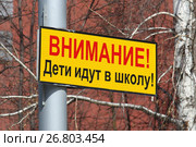 Предупреждающая табличка на столбе с надписью "Внимание! Дети идут в школу!" над проезжей частью улицы в городе Новосибирске (2017 год). Стоковое фото, фотограф Григорий Писоцкий / Фотобанк Лори