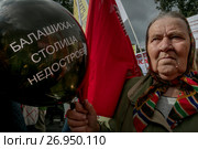 Крупным планом участник митинга обманутых дольщиков площади Революции города Москвы держит шарик с надписью "Балашиха - столица недостроев", Россия (2017 год). Редакционное фото, фотограф Николай Винокуров / Фотобанк Лори