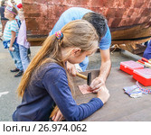 Москвичи и гости столицы на Тверской улице во время праздника Дня города. Изготовление памятной таблички (2017 год). Редакционное фото, фотограф Виктор Тараканов / Фотобанк Лори