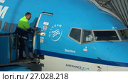 Пилот пассажирского самолета авиакомпании KLM готовится к вылету. Аэропорт Скипхол, Амстердам (2017 год). Редакционное видео, видеограф Виктор Карасев / Фотобанк Лори