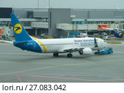 Буксировка самолета й Боинг-737 (UR-PSR) Украинских международный авиалиний в аэропорту Схипхол (2017 год). Редакционное фото, фотограф Виктор Карасев / Фотобанк Лори