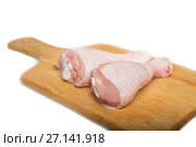 Two raw chicken drumsticks on a cutting board on a white background. Стоковое фото, фотограф Юлия Бабкина / Фотобанк Лори