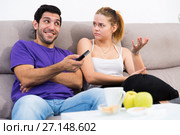 Woman trying to take away TV remote from boyfriend. Стоковое фото, фотограф Яков Филимонов / Фотобанк Лори