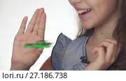 Beautiful cheerful teen girl playing with green fidget spinner on white background stock footage video. Стоковое видео, видеограф Юлия Машкова / Фотобанк Лори