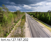 Country asphalt road among forests. Rain clouds in sky. Summer season, Karelia, Russia. Стоковое фото, фотограф Кекяляйнен Андрей / Фотобанк Лори