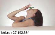Beautiful cheerful teen girl spinning a green fidget spinner on her nose on white background stock footage video. Стоковое видео, видеограф Юлия Машкова / Фотобанк Лори