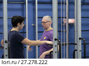 Инструктор в центре Бубновского разъясняет пациенту порядок выполнения упражнений (2017 год). Редакционное фото, фотограф Дмитрий Неумоин / Фотобанк Лори