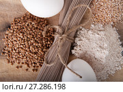 Products made from buckwheat on a wooden table close-up: noodles (soba), buckwheat, flour and cereals. Стоковое фото, фотограф Olesya Tseytlin / Фотобанк Лори
