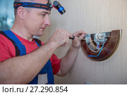 Male electrician connects the lamp on the wall. Стоковое фото, фотограф Наталья Давыдова / Фотобанк Лори