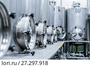 A lot of stainless steel tanks with large round hatches, modern beverage production. Стоковое фото, фотограф Андрей Радченко / Фотобанк Лори