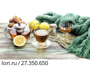 Useful herbal tea with a plant (Sideritis scardica) or Greek mountain tea with lemon in a cup and yellow chrysanthemums on a wooden table  close-up. Стоковое фото, фотограф Татьяна Ляпи / Фотобанк Лори