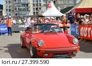 LE MANS, FRANCE - JUNE 16, 2017: Sports red porsch with gold trophy of a race of 24 hours of Le mans at the parade of pilots racing. Редакционное фото, фотограф Irina Kuchugurina/Gaudy / Фотобанк Лори