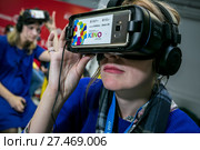 Девушка в Samsung Gear VR очках увлеченно смотрит фильм в кинотеатре виртуальной реальности в городе Сочи, Россия (2017 год). Редакционное фото, фотограф Николай Винокуров / Фотобанк Лори