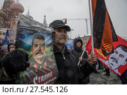 Мужчина держит портрет Сталина во время митинга-концерта "Россия в моем сердце" на Васильевском спуске города Москвы, Россия, 3 февраля 2018. Редакционное фото, фотограф Николай Винокуров / Фотобанк Лори