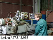 A woman works on an internal grinding machine. Stage of metal finishing of parts. (2017 год). Редакционное фото, фотограф Андрей Радченко / Фотобанк Лори