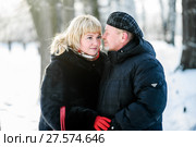 Счастливая семья. Мужчина и женщина среднего возраста стоят в обнимку на прогулке в зимним парке. Стоковое фото, фотограф Игорь Низов / Фотобанк Лори