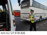 Инспектор дорожно-патрульной службы полиции остановил для проверки междугородний пассажирский автобус (2017 год). Редакционное фото, фотограф Free Wind / Фотобанк Лори