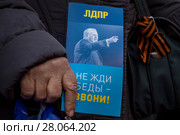 Пожилая женщина держит листовку кандидата в президенты Владимира Жириновского на митинге-концерте партии ЛДПР в честь Дня защитника Отечества на Пушкинской площади в центре города Москвы, Россия (2018 год). Редакционное фото, фотограф Николай Винокуров / Фотобанк Лори