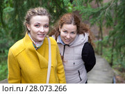 Две молодые улыбающиеся женщины смотрят в камеру на прогулке в лесу. Стоковое фото, фотограф Кекяляйнен Андрей / Фотобанк Лори