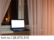 Laptop with cutout screen of monitor laying on windowsill at evening time in room. Стоковое фото, фотограф Кекяляйнен Андрей / Фотобанк Лори