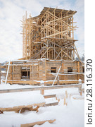 Wooden old-style building under construction and scaffolding in Russian Orthodox Monastery at winter day. Стоковое фото, фотограф Losevsky Pavel / Фотобанк Лори