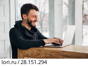 Stylish male freelancer working on new startup project making internet researchers analyzing data using laptop computer. Стоковое фото, фотограф Виктор Аллин / Фотобанк Лори