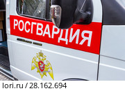 Inscription "Rosgvardia" and emblem of the troops of the National Guard of the Russian Federation on the board of car. Стоковое фото, фотограф FotograFF / Фотобанк Лори