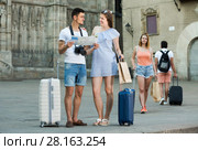 Family couple with luggage checking direction in map. Стоковое фото, фотограф Яков Филимонов / Фотобанк Лори