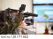 Operator with black camera is recording video in office, shallow dof. Стоковое фото, фотограф Losevsky Pavel / Фотобанк Лори