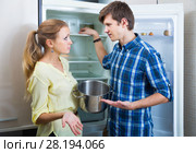 Frustraited starving female and man near fridge without any food. Стоковое фото, фотограф Яков Филимонов / Фотобанк Лори