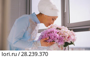 Muslim bride in blue wedding dress for nikah, smelling flowers. Стоковое фото, фотограф Константин Шишкин / Фотобанк Лори
