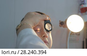 Child in an ophthalmic clinic. Examination of the child's eye fundus using a magnifying glass. Стоковое видео, видеограф Константин Мерцалов / Фотобанк Лори