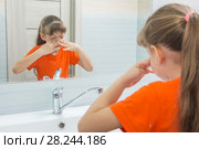 Семилетняя девочка умывается в ванне, моет водой лицо. Стоковое фото, фотограф Иванов Алексей / Фотобанк Лори