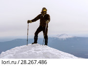 Mountaineer in a windproof mask and glasses reached the snow top of the mountain. Стоковое фото, фотограф Евгений Харитонов / Фотобанк Лори