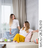 Two young girls are sitting on the couch. Стоковое фото, фотограф Типляшина Евгения / Фотобанк Лори
