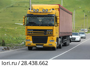 Грузовая машина-фура DAF XF 95 желтого цвета с украинскими номерами едет по военно-грузинской дороге летом. Республика Грузия (2017 год). Редакционное фото, фотограф Алексей Гусев / Фотобанк Лори